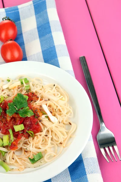 Tasty spaghetti with sauce and vegetables on plate on wooden table close-up — Stock Photo, Image