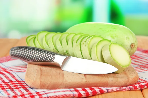 Fresh marrows on cutting board, on wooden table, on bright background — Stock Photo, Image