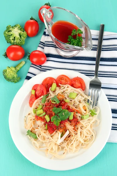 Smaczne spaghetti z sosem i warzywami na tabliczce na drewniany stół szczegół — Zdjęcie stockowe