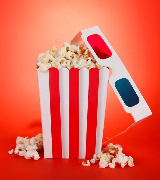 Popcorn i okulary 3d na czerwonym tle — Zdjęcie stockowe