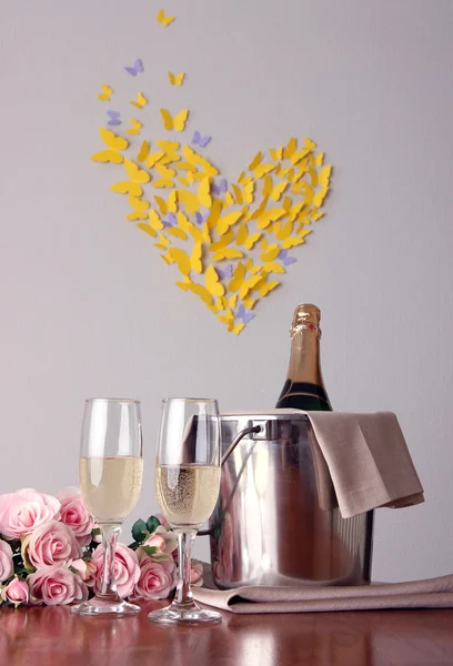 Šampaňské a brýle na kulatý stůl na pozadí místnosti — Stock fotografie