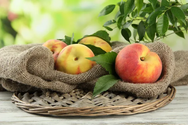 Ripe sweet peaches on wooden table in garden, close up — Stock Photo, Image