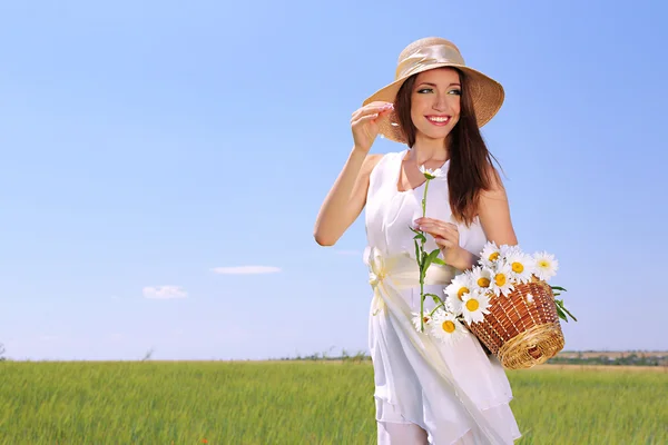 Ritratto di bella giovane donna con fiori nel campo — Foto Stock