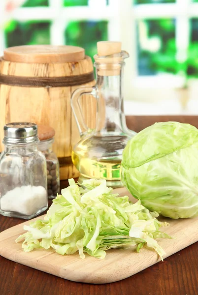 Green cabbage, oil, spices on cutting board, on bright background — Stock Photo, Image