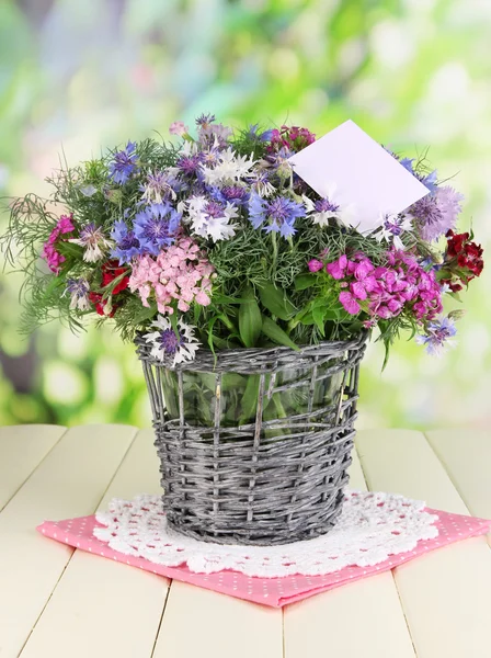 Beau bouquet dans le panier sur table en bois sur fond naturel — Photo