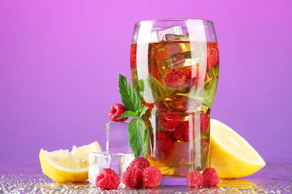 Té helado con frambuesas y menta sobre fondo morado —  Fotos de Stock