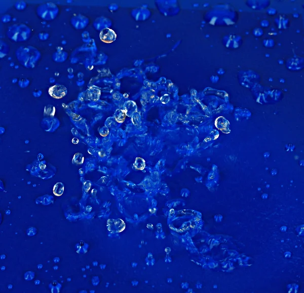 Vatten droppar på blå plast bakgrund — Stockfoto
