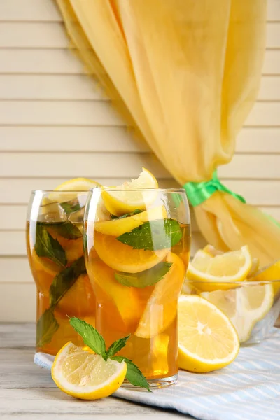 Холодный чай с лимоном и мятой на деревянном столе — стоковое фото