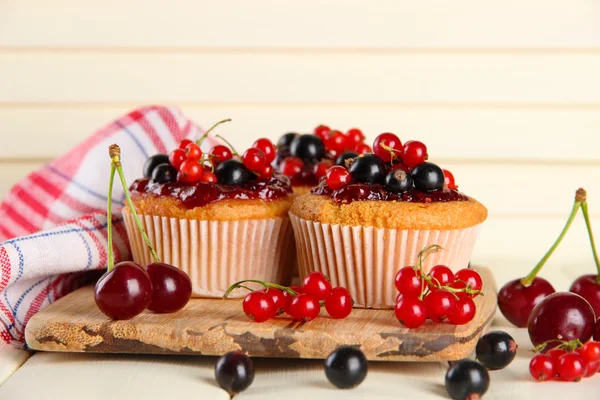 Muffin lezat dengan buah beri di atas meja kayu putih — Stok Foto