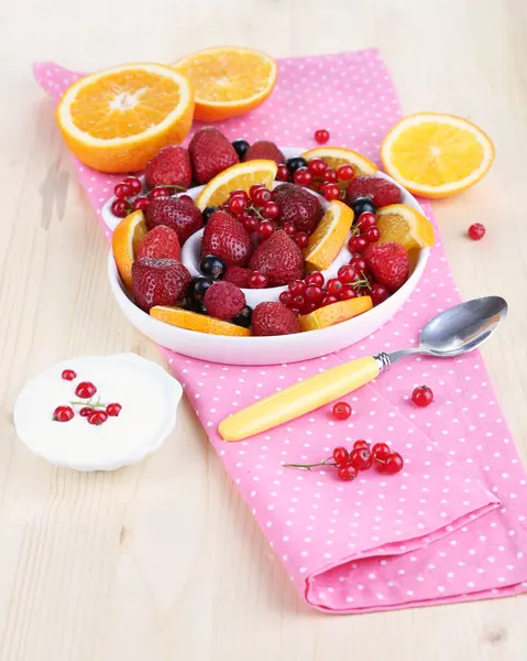 Useful fruit salad in plate on wooden table close-up — Stock Photo, Image