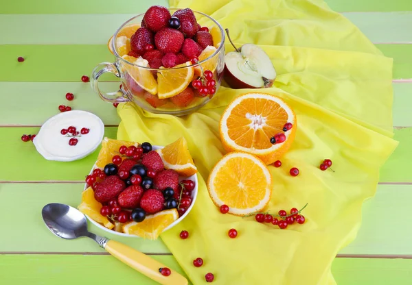 Insalata di frutta utile in tazza di vetro e ciotola sul tavolo di legno primo piano — Foto Stock