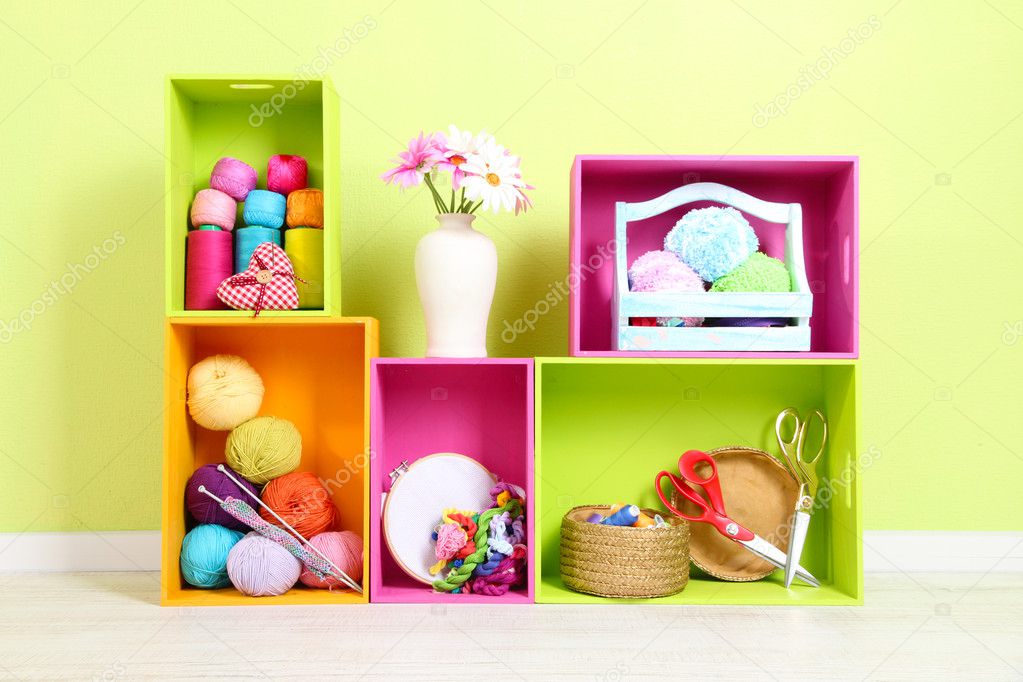 Colorful shelves of different colors with utensils on wall background