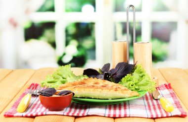 parlak zemin üzerine ahşap masa üzerinde plaka üzerinde taze otlar ile lezzetli chebureks