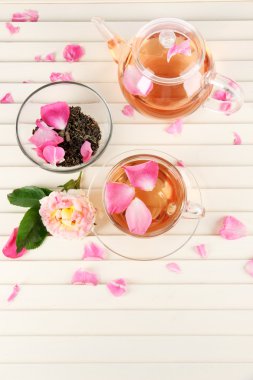 Kettle ve çay gülü peçete ahşap zemin üzerinde gelen