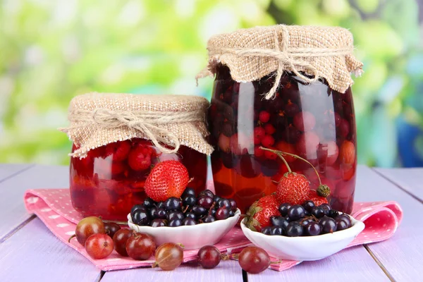 Huisgemaakte berry jam op houten tafel op lichte achtergrond — Stockfoto