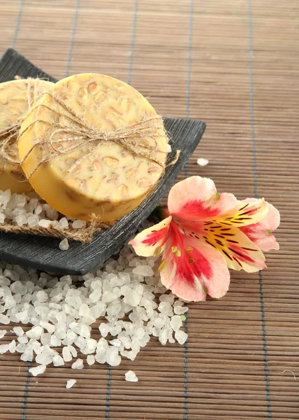 Jabón y sal marina hechos a mano en estera de bambú gris —  Fotos de Stock