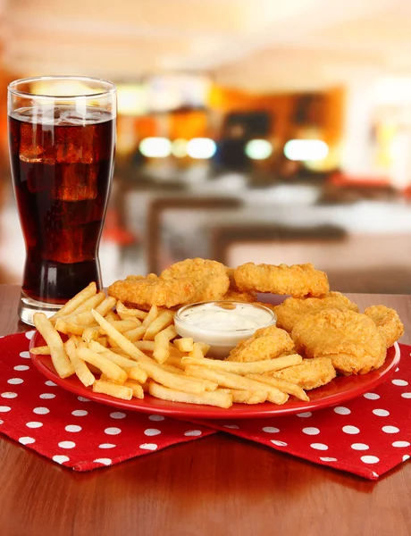 Sült csirke rögök, sült krumplival, a cola és a szósz a kávézó asztal — Stock Fotó
