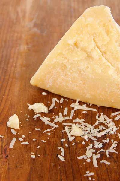 Piece of Parmesan cheese on wooden table close-up — Stock Photo, Image