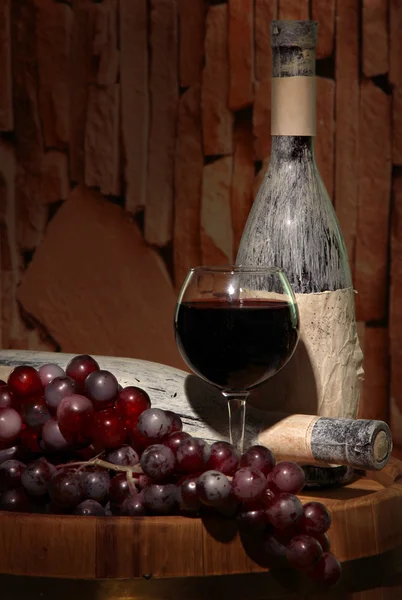 Komposition mit alter Flasche Wein und Weinglas im alten Keller, auf dunklem Hintergrund — Stockfoto
