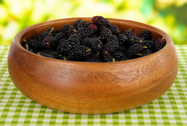 Moras maduras en tazón sobre mesa sobre fondo brillante —  Fotos de Stock