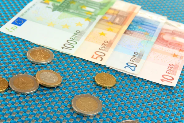 Euro banknotes and euro cents on blue background — Stock Photo, Image