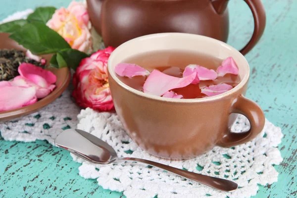 Wasserkocher und Tasse Tee aus Teerose an Bord auf Serviette auf Holzgrund — Stockfoto