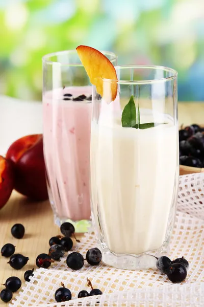 Heerlijke melk schudt met blackberry en peach op houten tafel op natuurlijke achtergrond — Stockfoto