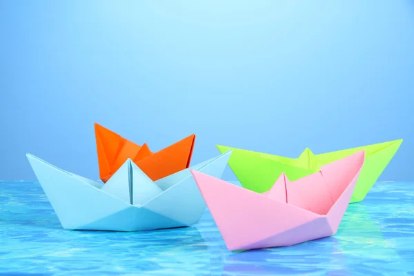 Barcos de papel de diferentes colores sobre fondo de agua —  Fotos de Stock