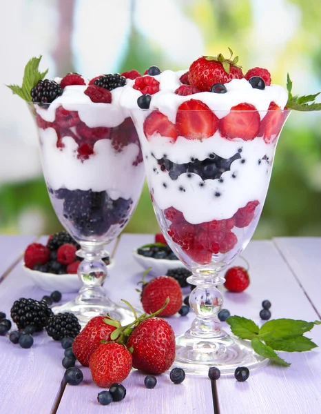 Přírodní jogurt s čerstvým ovocem na dřevěný stůl na zeleném pozadí — Stock fotografie