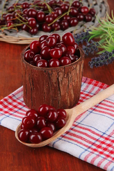 Søtkirsebær i trekurv på bordet. – stockfoto