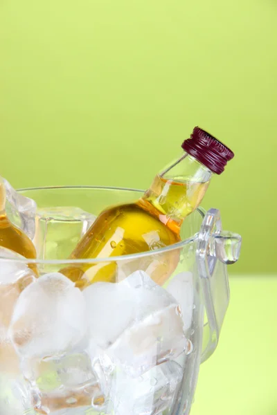 Minibar bottles in bucket with ice cubes, on color background — Stock Photo, Image