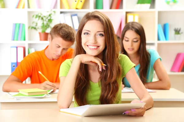 Group of young students sitting at the library — Stock Photo, Image