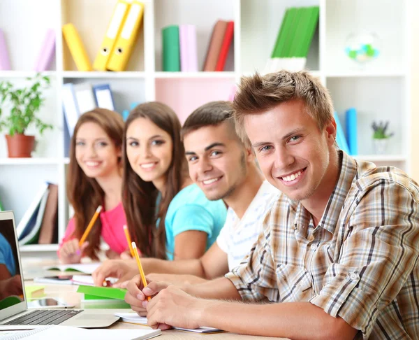 Gruppo di giovani studenti seduti in biblioteca — Foto Stock