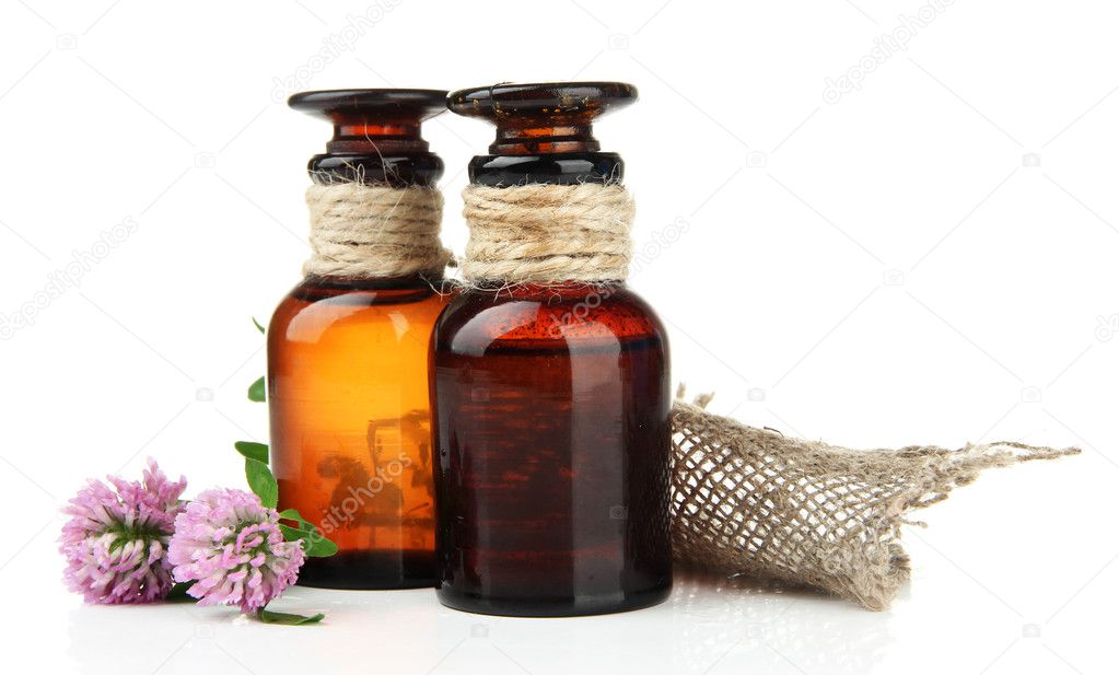 Medicine bottles with clover flowers, isolated on white