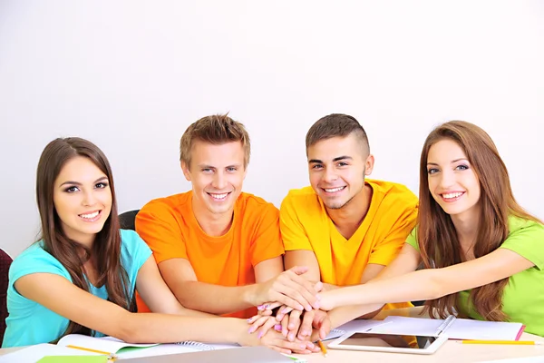 Grupo de jóvenes estudiantes sentados en la habitación — Foto de Stock