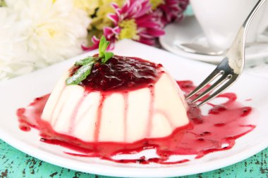 Panna cotta renk ahşap zemin üzerinde frambuaz sos ile
