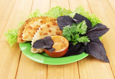 ahşap zemin üzerinde plaka üzerinde taze otlar ile lezzetli chebureks