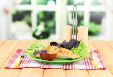 parlak zemin üzerine ahşap masa üzerinde plaka üzerinde taze otlar ile lezzetli chebureks