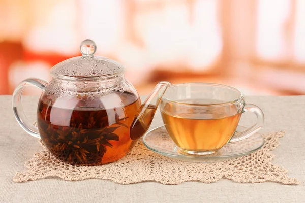 Té verde exótico con flores en tetera de vidrio sobre fondo brillante — Foto de Stock