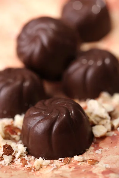 Chocolate candies with nuts, on color background — Stock Photo, Image