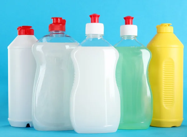 Bottles of dishwashing liquid on color background — Stock Photo, Image