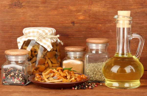 Složení vynikající marinované houby, oleje a koření na dřevěný stůl na dřevěné pozadí — Stock fotografie