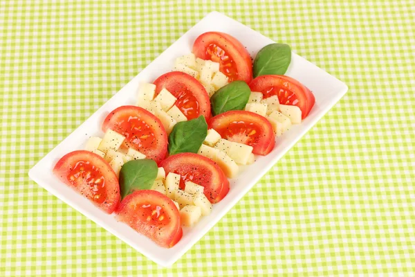 Mozzarella au fromage avec légumes dans une assiette sur la table — Photo