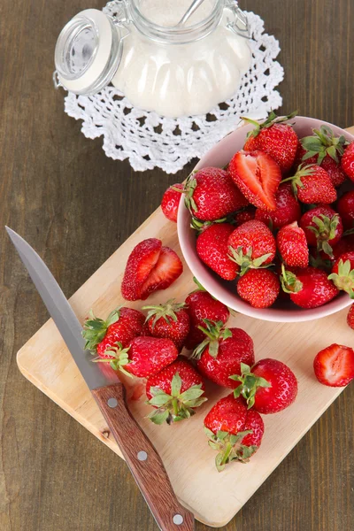 Erdbeeren in Schüssel auf Holztisch schneiden — Stockfoto