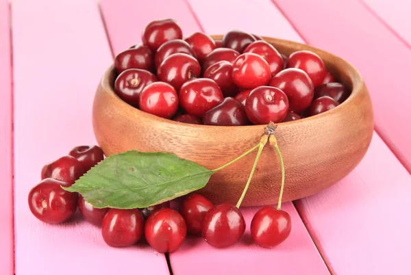 Cherry berries in bowl on wooden table close-up — Stock Photo, Image