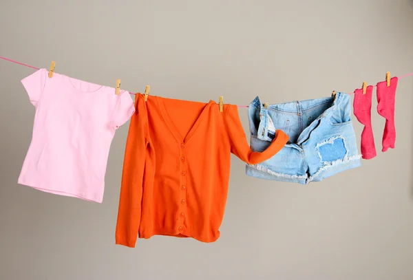 Laundry line with clothes on wall background — Stock Photo, Image