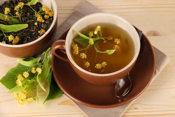 Kopje thee met linden op servet houten tafel — Stockfoto