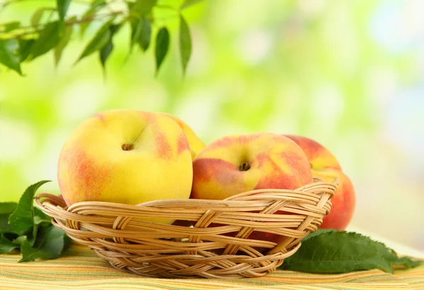 Maturi dolci pesche in cesto su tavolo, all'aperto — Foto Stock