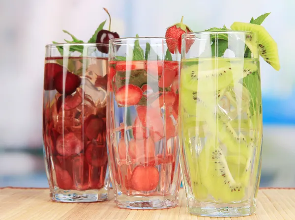 Copos de bebidas de frutas com cubos de gelo na mesa no café — Fotografia de Stock