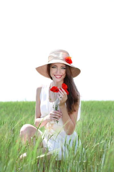 Retrato de una hermosa joven con amapolas en el campo — Foto de Stock